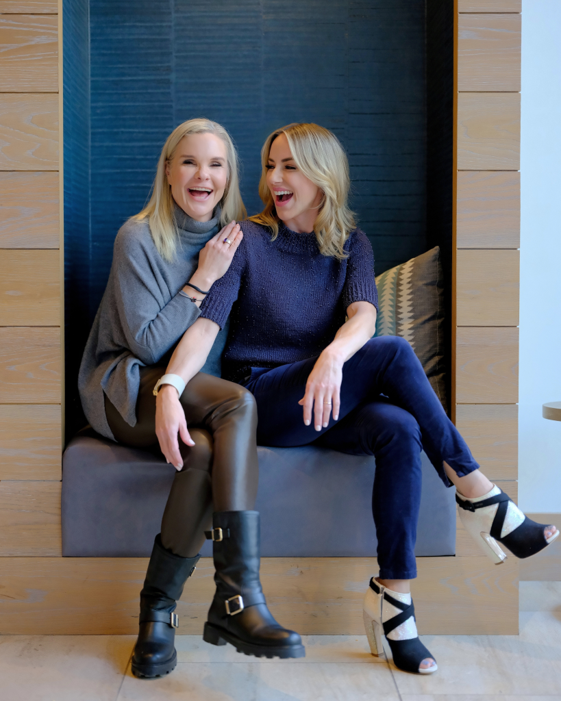 Dierdre Slavin, founder- ceo, and Dr. Wendi Harper Lonabough sharing a boisterous laugh, showcasing genuine connection, joy, and authenticity in the medical aesthetics industry.