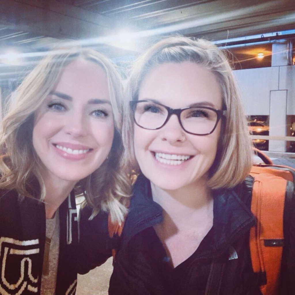 Dierdre Slavin and Dr. Wendi Harper Lonabough smiling together at an airport, showcasing their long-standing friendship and collaboration in medical aesthetic training since 2015.