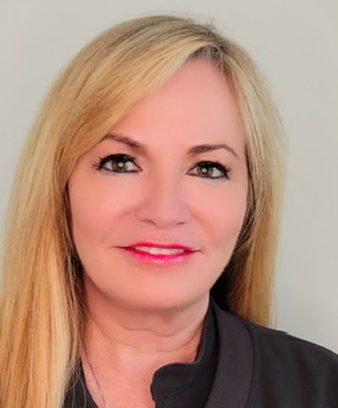 Professional headshot of Patricia Kiernan, a nurse injector in Dallas, TX, wearing a black zip-up jacket and smiling confidently after attending Heddy’s expert injector training.