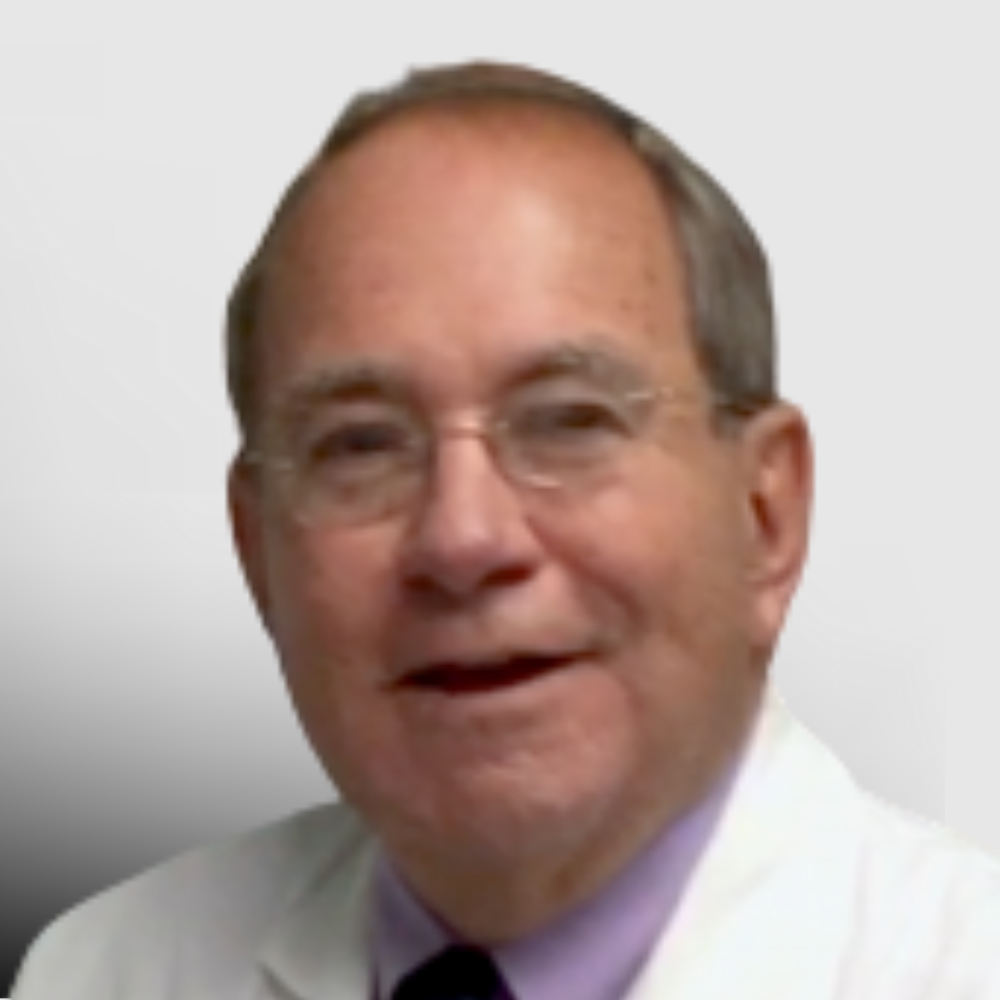 Headshot of Dr. Donald Clemons, a senior male dermatologist from Tennessee wearing a white coat and glasses, smiling slightly against a gradient background.
