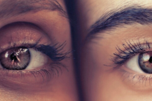 Extreme close-up of two diverse human eyes symbolizing patient individuality and introspection in the evolving field of medical aesthetics.