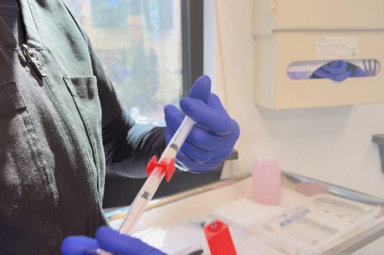 Gloved clinician preparing a syringe in a medical aesthetics treatment room, representing operational processes tied to medspa financial performance and due diligence
