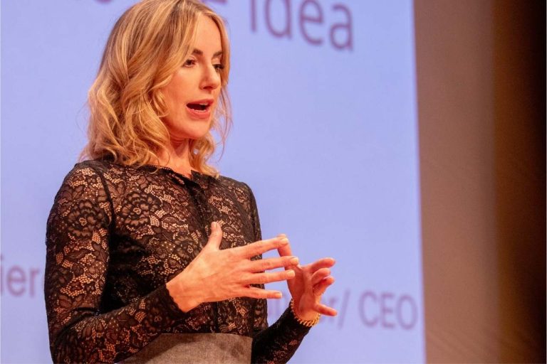 Dierdre Slavin speaking on stage at a healthcare and entrepreneurship conference on medical aesthetics commercial strategy and industry leadership