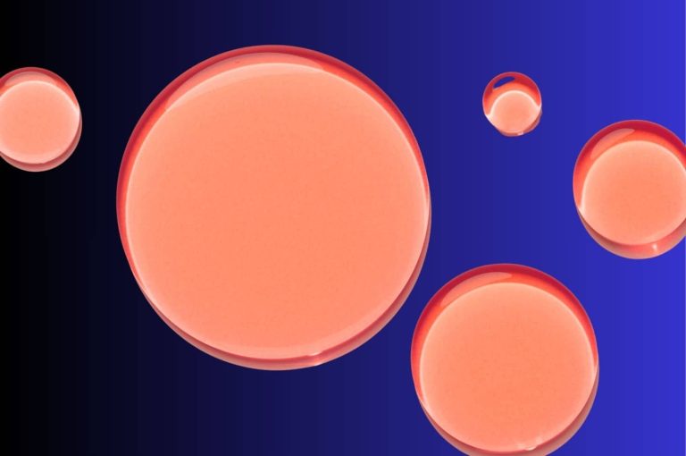 Abstract graphic of pink translucent liquid droplets on a blue background, representing smart hyaluronic acid fillers formulated with niacinamide in the Injectopedia Library.